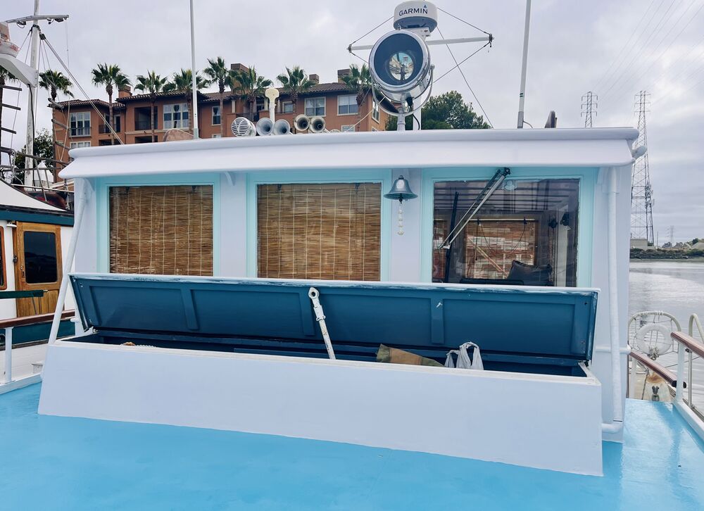 The deck box on the foredeck, lid propped open, in front of the pilothouse.